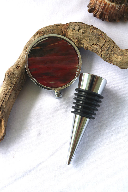 Wine Bottle Stopper on a piece of driftwood on a white background. 