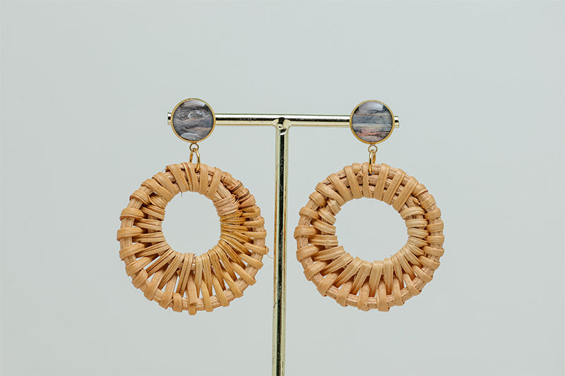 Boho Rattan Hoop Earrings on a gold stand on a white background.