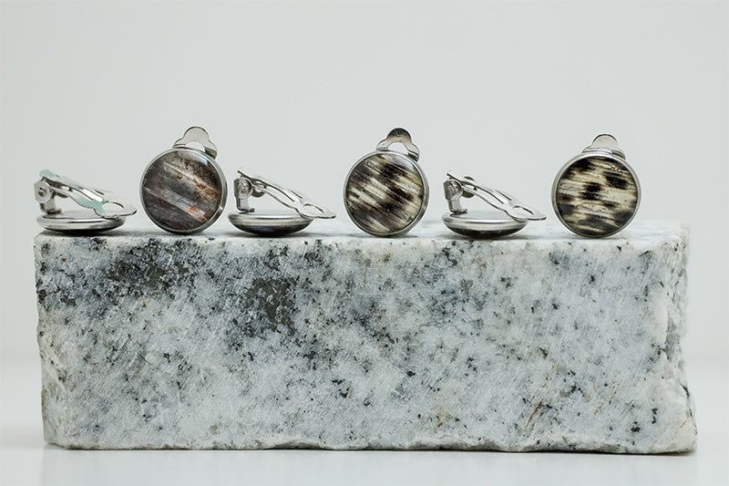 Three pairs of Clip-On Earrings on black and white marble on a white background.