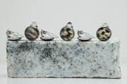 Three pairs of Clip-On Earrings on black and white marble on a white background.