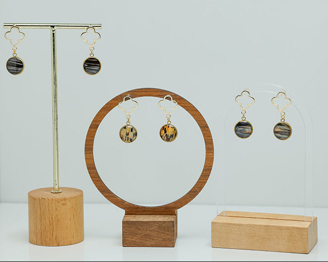 Three pairs of Four Leaf Clover Earrings on stands on a white background.  