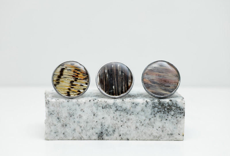Three Silver Statement Rings on black and white marble on a white background.
