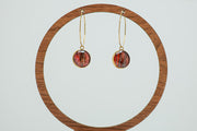 Gold Hexagon Hoops on a circular wooden stand on a white background.  