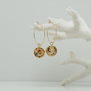 Gold Hoops on white coral on a white background.