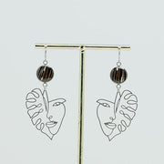 Into the Jungle Earrings on a gold stand on a white background.