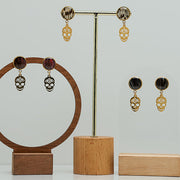 Three pairs of Sugar Skull Earrings on stands on a white background.  