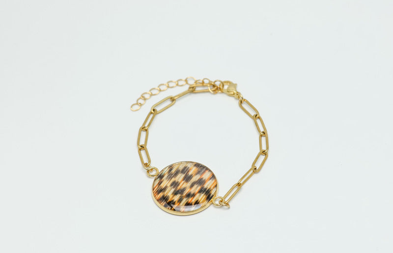 A Gold Paperclip Bracelet on a white background. 
