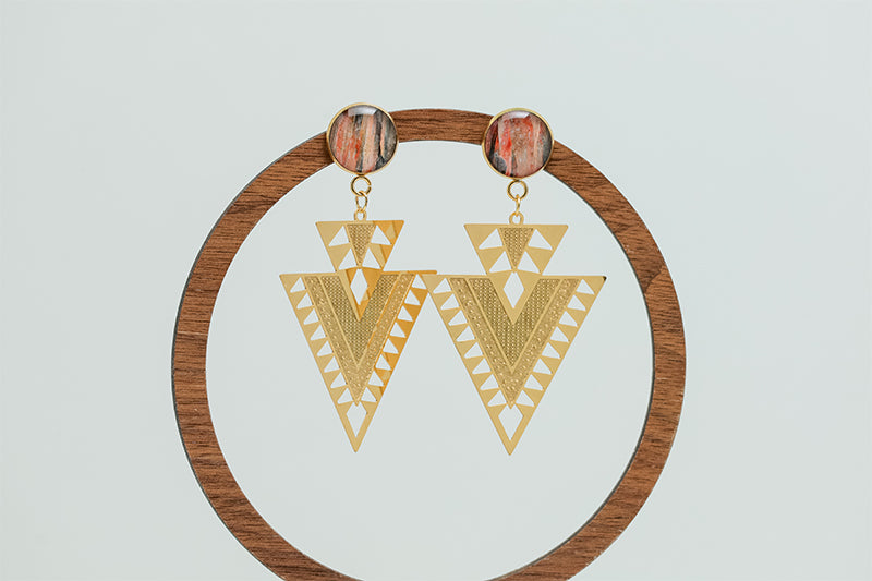 Aztec Inspired Earrings on a circular wooden stand on a white background.  