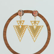 Aztec Inspired Earrings on a circular wooden stand on a white background.  