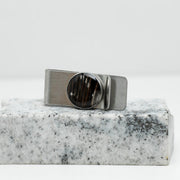 Silver Money Clip on a piece of white and black marble on a white background. 
