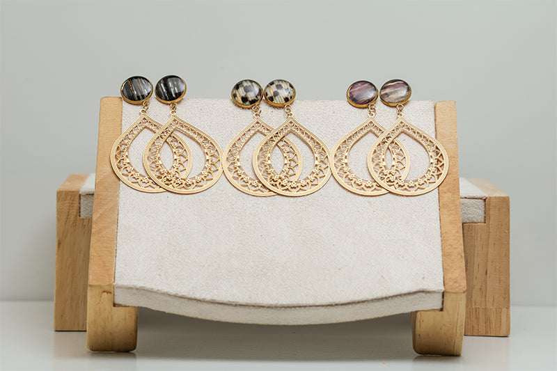 Three pairs of Teardrop Lace Earrings on a cream stand on a white background.