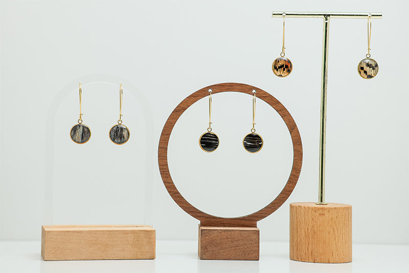 Three pairs of Golden Leverback Earrings on stands on a white background.  