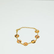 A Gold Tennis Bracelet with six tailfin charms on a white background.