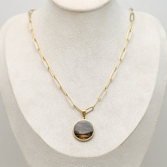 Large gold lionfish fin pendant necklace with paperclip chain and 20mm round resin pendant on cream jewelry bust