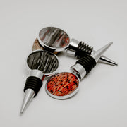 Three silver lionfish fin wine bottle stoppers with round resin charms in tail, pectoral, and pelvic fin variants displayed together on white background