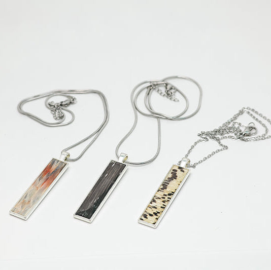 Three Silver Bar Necklaces on a white background.