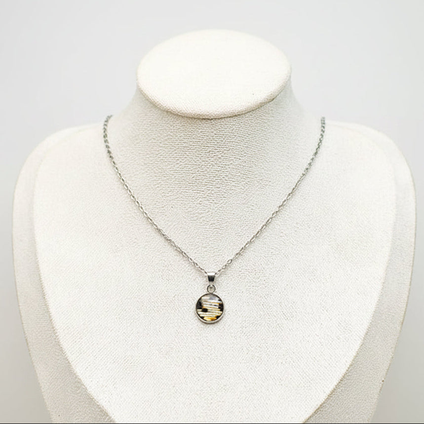 Small silver lionfish necklace showcasing tail fin design, sustainable handmade ocean jewelry