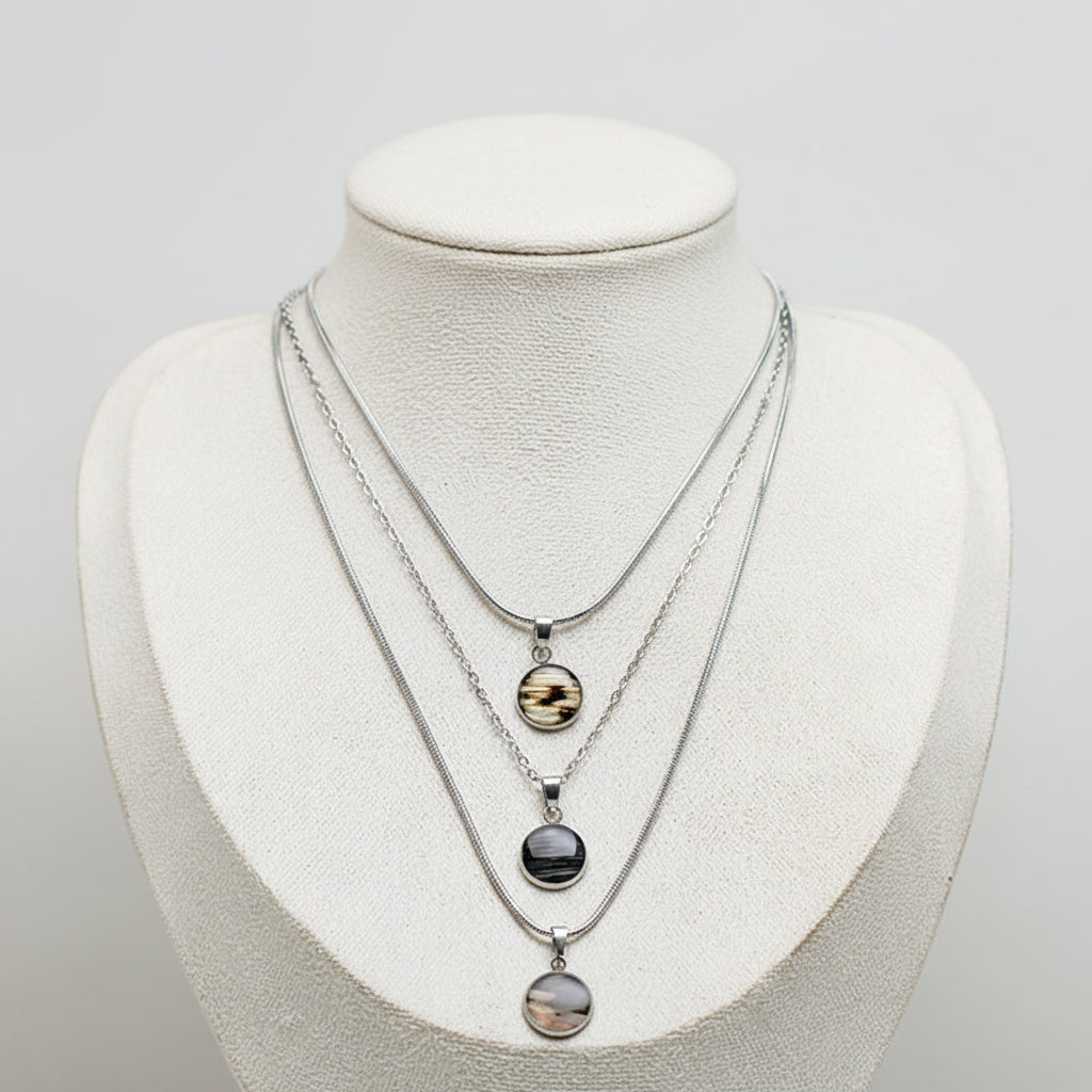 Small silver lionfish necklace showcasing three fin designs, sustainable handmade ocean jewelry